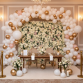 Luxury balloon arch in white, gold and blush tones with floral backdrop wall for an elegant event