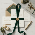 Luxury event invitations with gold foil lettering, wax seal and premium paper in an elegant flat lay